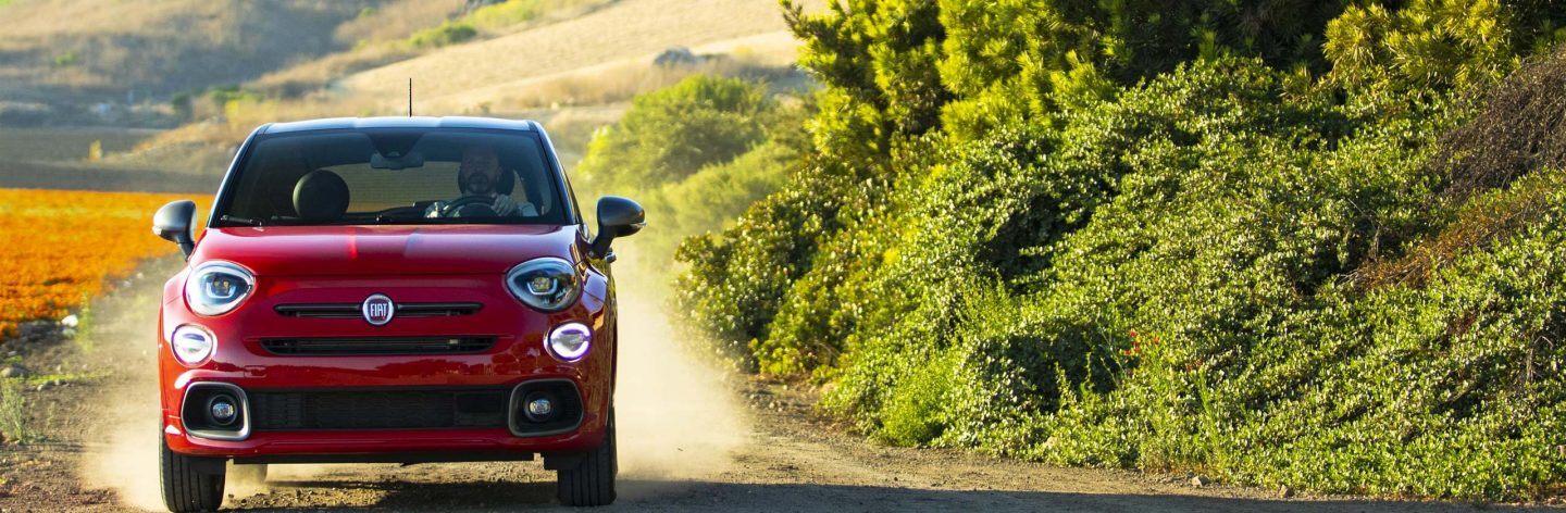 The 2021 Fiat 500X Sport being driven on a dusty country road.
