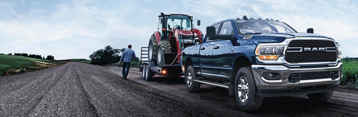 The 2022 Ram 2500 towing a tractor on a trailer.